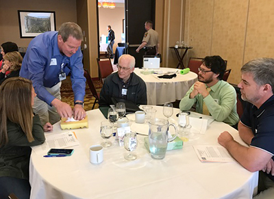 Group at a table, with one person leading an activity.